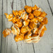 orange popcorn with white drizzle on a wooden surface