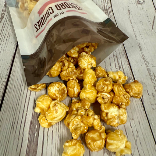 Bag of popcorn spilling onto a wooden surface