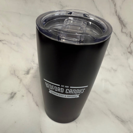 Black insulated tumbler with a clear lid on a marble surface