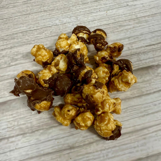 Chocolate-covered popcorn on a light wooden surface
